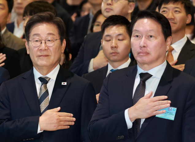 이재명 대통령이 20일 울산전시컨벤션센터에서 열린 울산 인공지능(AI) 데이터센터 출범식에서 국기에 경례하고 있다. 이 대통령 오른쪽은 최태원 SK그룹 회장. 대통령실통신사진기자단