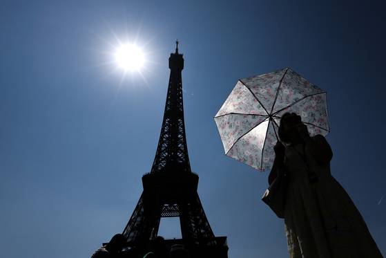 한 관광객이 프랑스 파리 에펠탑 인근에서 양산으로 햇빛을 막고 있다. 로이터=연합뉴스