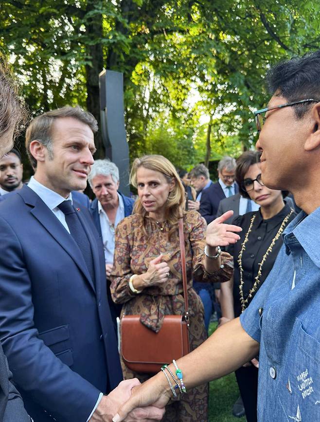 French President Emmanuel Macron shakes hands with Lee Soo-man, leader of A20 Entertainment, during a meeting at the Elysee Palace in Paris on June 20. (A20 Entertainment)