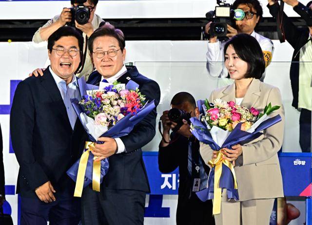 이재명 대통령 당선인이 4일 서울 여의도 국회 앞을 찾아 박찬대 상임총괄선대본부장으로부터 꽃다발을 받고 있다. 뉴스1