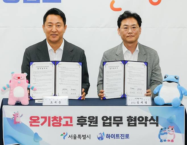 오세훈 서울시장이 23일 서울 영등포쪽방상담소에서 열린 온기창고 개소식에서 하이트진로와 업무 협약식을 하고 있다.