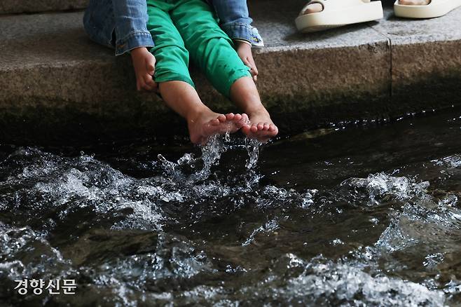 23일 서울 청계천을 찾은 시민들이 발을 물에 담그고 있다.