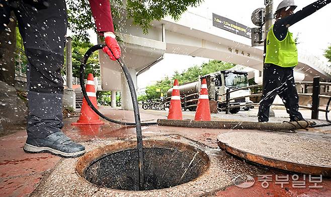 최근 장마철이 다가오며 지속적인 빗물받이와 배수관 관리가 요망되는 가운데 24일 오후 수원시 장안구 한 인도변에서 하수도 작업 관계자들이 준설장비를 동원해 배수관 내부의 오물을 제거하고 있다. 김경민기자