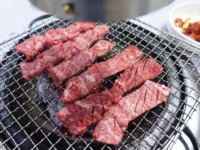 한우가 숯불 위에서 맛있게 익고 있다.