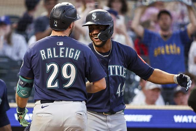 시애틀 매리너스 칼 롤리가 24일(한국시각) 타깃필드에서 열린 미네소타 트윈스전에서 9회초 좌월 투런홈런을 터뜨리고 들어와 훌리오 로드리게스의 축하를 받고 있다. AP연합뉴스