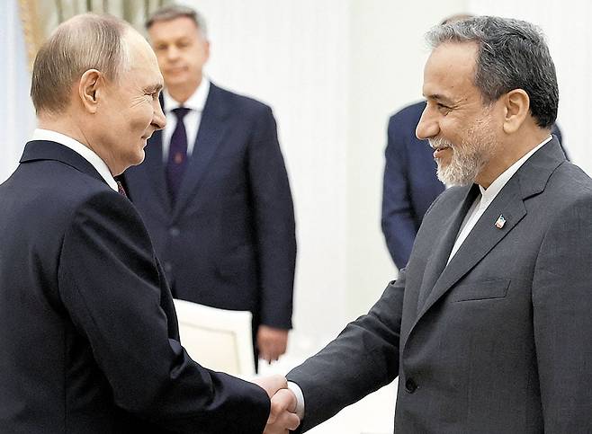 푸틴 만난 이란 외무장관 - 러시아를 찾은 아바스 아라그치(오른쪽) 이란 외무장관이 23일 모스크바 크렘린궁에서 블라디미르 푸틴 러시아 대통령과 악수를 나누고 있다. /AFP 연합뉴스