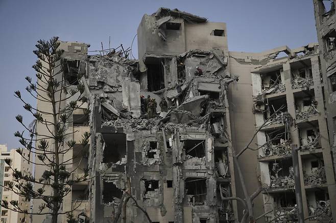 24일(현지 시간) 이스라엘 남부 베르셰바에서 군인과 구조대가 이란의 미사일 공격으로 파괴된 주거 건물 잔해를 수색하고 있다. 도널드 트럼프 미국 대통령이 이란과 이스라엘이 휴전에 합의했다고 발표한 가운데 이란의 공습으로 이스라엘 남부에서 최소 4명이 숨졌다. 베르셰바=AP/뉴시스