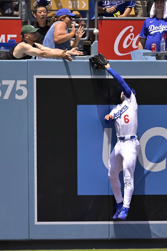 LA 다저스 김혜성이 23일(한국시간) 워싱턴과의 경기에서 담장을 넘어가는 네이트 로우의 타구를 잡기 위해 뛰어오르고 있다. LA | AFP연합