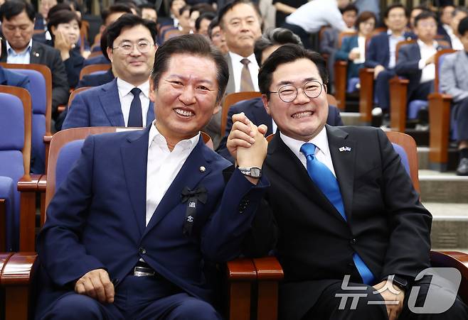 더불어민주당 당대표 출마를 선언한 박찬대(오른쪽), 정청래 의원이 24일 서울 여의도 국회에서 열린 의원총회에 참석, 취재진을 향해 손을 들어보이고 있다. 2025.6.24/뉴스1 ⓒ News1 김민지 기자