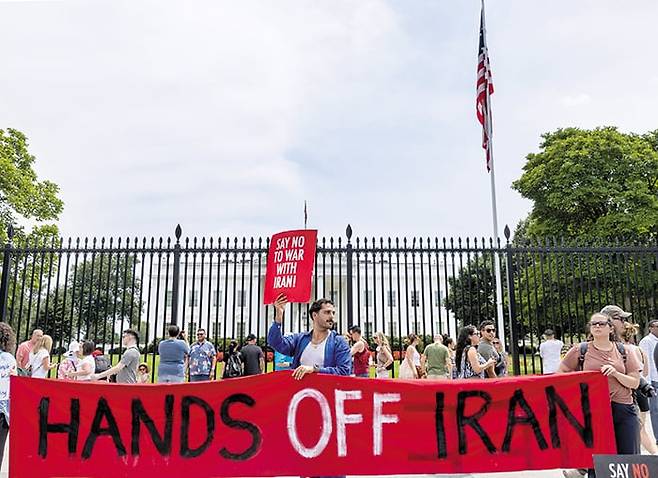 지난 22일 미국 워싱턴 DC 백악관 앞에서 미국의 이란 핵 시설 폭격에 항의하는 시위대가 “이란에 손 떼라(Hands off Iran)”라고 적힌 플래카드를 들고 시위를 벌이고 있다. /신화 연합뉴스
