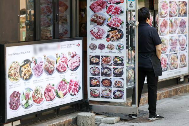 12일 서울 중구 명동 한 식당 주인이 문 밖에 나와 손님을 기다리고 있다. 뉴스1