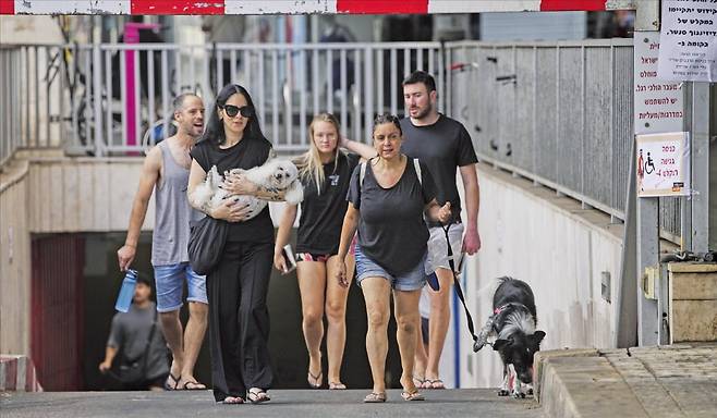 < ‘공습경보 끝’ > 이스라엘 텔아비브 시민들이 24일 이란의 미사일 공습 경보가 끝난 뒤 피란처인 지하주차장에서 나오고 있다. AP연합뉴스