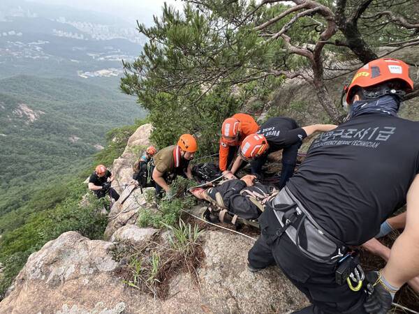 고양소방서 구조대원들이 북한산 의상봉 정상 부근에서 절벽 아래로 추락한 등산객을 구조하고 있다. 고양소방서 제공