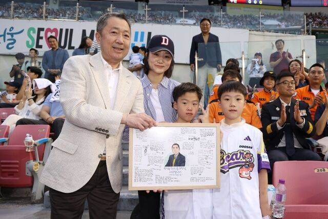 2018년 순직한 故심문규 소방장 유가족에게 AI 복원 가족사진, 쌍둥이 자녀에게 선물 전달하고 있는 박정원 구단주./두산 베어스