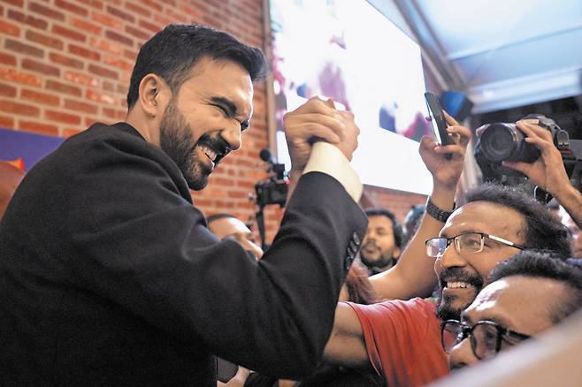 25일 조란 맘다니(왼쪽) 미국 뉴욕주 의원이 이날 열린 민주당 뉴욕 시장 후보 예비 선거 개표를 지켜보던 중 지지자를 만나 웃으며 손을 맞잡고 있다. 무명에 가까웠던 신예 맘다니는 예비 선거에서 43.5% 득표율로 앤드루 쿠오모 전 뉴욕 주지사(36.4%)를 누르고 1위를 차지해 경선 승리가 확실시되고 있다./로이터 연합뉴스