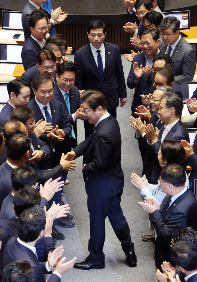 이재명 대통령이 26일 서울 여의도 국회에서 열린 본회의에서 추가경정예산 시정연설을 하기 위해 입장하며 의원들과 인사를 하고 있다. 성형주 기자
