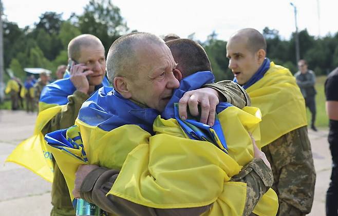 러시아와의 포로 교환으로 석방된 우크라이나 군인들이 26일(현지시각) 알려지지 않은 장소에서 포옹하고 있다. EPA 연합뉴스