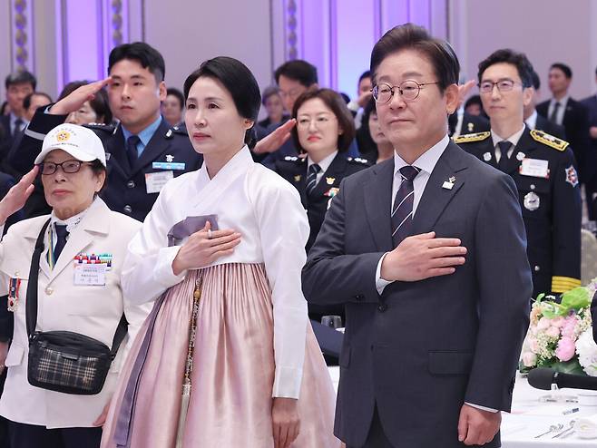 이재명 대통령과 김혜경 여사가 27일 청와대 영빈관에서 열린 '호국 보훈의 달, 대통령의 초대' 행사에서 국기에 경례하고 있다. ⓒ연합뉴스