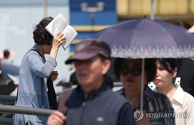 책으로 가려보는 햇볕 (대구=연합뉴스) 윤관식 기자 = 대구에 올해 첫 폭염주의보가 발령된 27일 동대구역 인근에서 한 시민이 책을 펼쳐 햇볕을 가리고 있다. 2025.6.27 psik@yna.co.kr