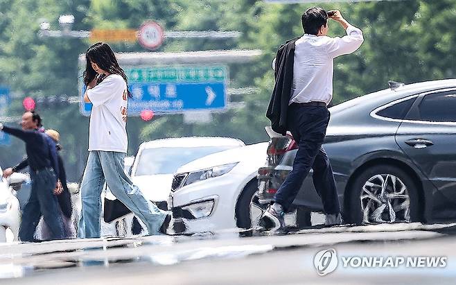 '폭염' (대구=연합뉴스) 윤관식 기자 = 대구에 올해 첫 폭염주의보가 발령된 27일 대구 중구 공평네거리 인근 국채보상로에서 시민들이 지열로 인한 아지랑이가 피어오르는 도로를 건너고 있다. 2025.6.27 psik@yna.co.kr