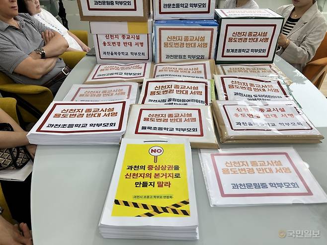 과천시초중고학부모연합회 관계자들이 27일 경기도 과천시청 민원실 앞에서 그동안 모은 신천지 반대 서명을 앞에 두고 이야기를 나누고 있다.