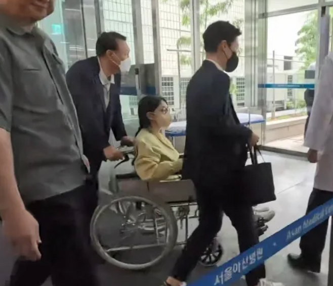 특별검사팀 출범을 앞두고 우울증 등 지병을 이유로 입원했던 김건희 여사가 27일 서울 송파구 서울아산병원에서 윤석열 전 대통령이 미는 휠체어에 탄 채 퇴원하고 있다. SBS·MBC·KBS·YTN·MBN 방송 풀 제공