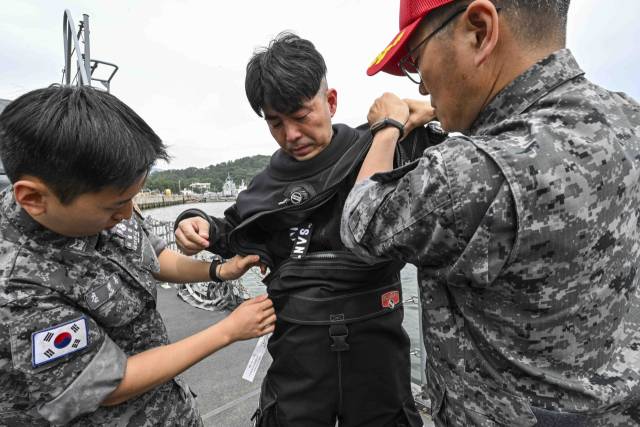 12일 경남 진해 해군기지 내 해군해난구조전대(SSU)에서 이현호 서울경제신문 기자가 드라이 잠수복을 착용하며 수중 잠수 훈련 과정을 체험하고 있다. 사진 제공=해군
