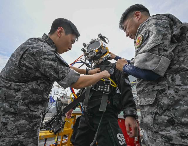 12일 경남 진해 해군기지 내 해군해난구조전대(SSU)에서 이현호 서울경제신문 기자가 드라이 잠수복을 착용하며 수중 잠수 훈련 과정을 체험하고 있다. 사진 제공=해군