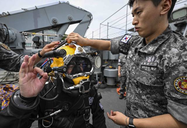 12일 경남 진해 해군기지 내 해군해난구조전대(SSU)에서 이현호 서울경제신문 기자가 드라이 잠수복을 착용하며 수중 잠수 훈련 과정을 체험하고 있다. 사진 제공=해군