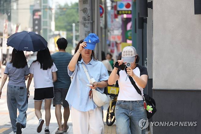 '너무 뜨거워…대구 폭염경보' (대구=연합뉴스) 박세진 기자 = 28일 대구에 폭염경보(군위 제외)가 내려진 가운데 중구 동성로에서 시민들이 햇볕을 가리며 발걸음을 옮기고 있다. 2025.6.28 psjpsj@yna.co.kr