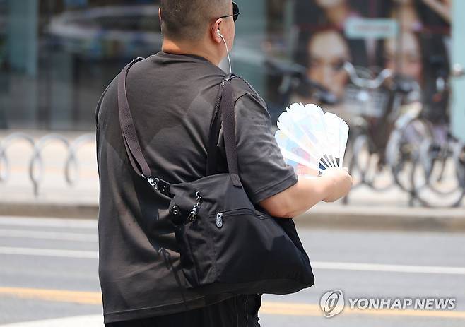 '덥다 더워…대구 폭염경보' (대구=연합뉴스) 박세진 기자 = 28일 대구에 폭염경보(군위 제외)가 내려진 가운데 중구 동성로에서 시민이 부채질을 하며 이동하고 있다. 2025.6.28 psjpsj@yna.co.kr