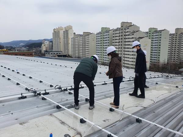 용인시 관계자들이 마평동 용인실내체육관 지붕에 설치된 유출지하수 활용 살수장치를 점검하고 있다. /용인시 제공