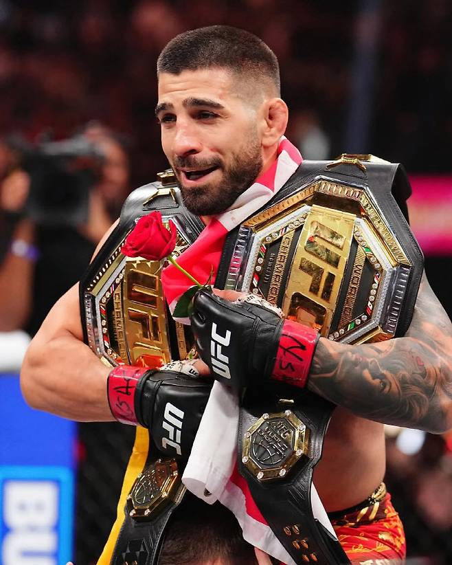 UFC 챔피언 벨트 두 개를 어깨에 짊어지고 기뻐하는 일리야 토푸리아. 사진=UFC