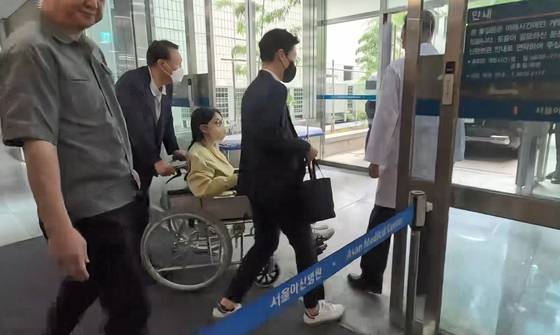 김건희 여사가 27일 서울 송파구 서울아산병원에서 윤석열 전 대통령이 미는 휠체어에 탄 채 퇴원하고 있다. 연합뉴스