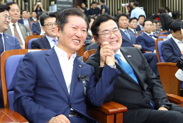 더불어민주당 당대표 후보인 정청래(왼쪽)·박찬대 의원이 24일 서울 여의도 국회에서 열린 의원총회에 참석해 손잡고 있다. 연합뉴스