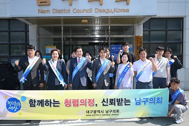 대구 남구의회 일부 의원들이 지난 27일 의회 건물 앞에서 ‘청렴 캠페인’을 벌이며 기념촬영을 하고 있다. 남구의회 제공