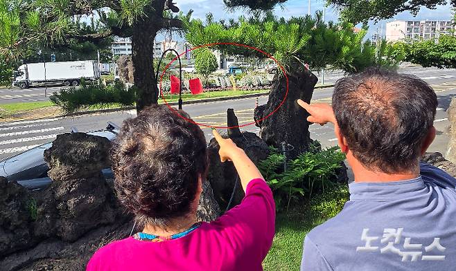 폐기물 처리 시설 반대 집회에 고통을 호소하는 사업자의 노부모가 집 앞에 걸린 현수막을 가리키고 있다. 이창준 크리에이터
