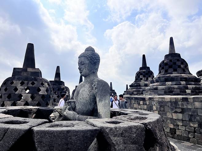보로부두르의 부도탑 사이, 그 목을 지켜낸 부처상.