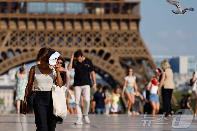 30일(현지시간) 찜통 더위 속 프랑스 수도 에펠탑 앞의 광장을 관광객과 시민들이 지나고 잇다. 2025.6.30 ⓒ AFP=뉴스1 ⓒ News1 이지예 객원기자