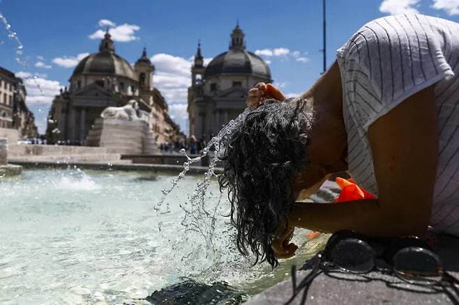 지난 29일(현지시간) 폭염 특보가 내려진 이탈리아 로마에서 한 시민이 분수 물에 머리를 감고 있다. EPA 연합뉴스