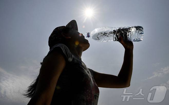 프랑스 서부 캥페르에서 한 여성이 갈증으로 물을 마시는 모습.ⓒ AFP=뉴스1
