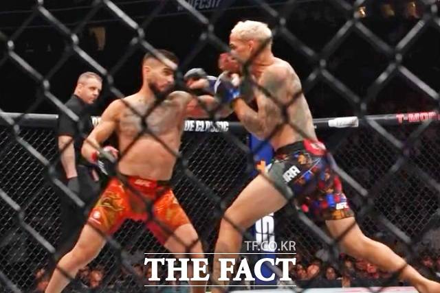 토푸리아(왼)가 지난달 29일(한국시간) 미국 네바다주 라스베이거스 T-모바일 아레나에서 열린 UFC 317 메인 이벤트 라이트급 타이틀전에 출전해 찰스 올리베이라와 타격전을 벌이고 있다. /UFC