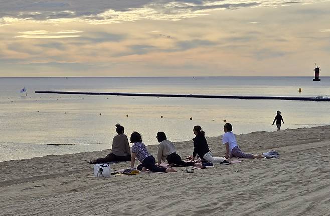 경포해변 백사장에서 1일 새벽 주민들이 요가하며 열대야의 아침을 맞고 있다. 2일 새벽 강릉 최저기온은 30.3도를 기록하며 초열대야 현상이 나타났다. 연합뉴스