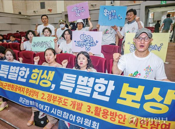 이재명 대통령이 경기 북부 반환 미군 공여지 처리를 전향적으로 검토하라고 지시한 가운데 2일 경기도청 북부청사에서 열린 ‘주한미군 공여구역 발전계획 변경안 공청회’에서 참석자들이 ‘특별한 희생, 특별한 보상’ 문구가 적힌 현수막을 들고 있다. 조주현기자