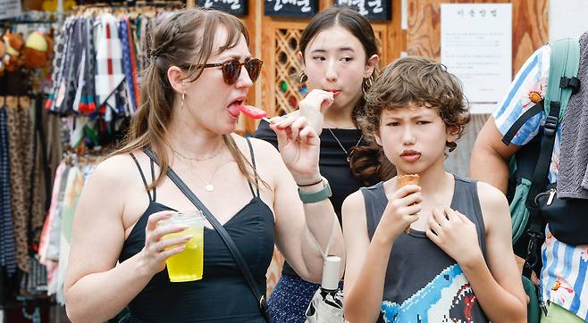 서울 최고온도 33도까지 올라 습하고 더운 날씨를 보인 2일 서울 종로구 북촌한옥마을에서 한 외국인 관광객 가족이 아이스크림을 먹고 있다.