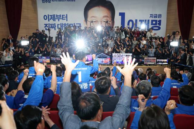 더불어민주당 박찬대, 윤여준 상임총괄선대위원장을 비롯한 선대위 관계자들이 지난달 3일 국회의원회관 개표상황실에서 제21대 대통령선거 지상파 출구조사 결과에서 이재명 후보가 51.7%로 앞서는 것으로 발표되자 환호하고 있다. 연합뉴스