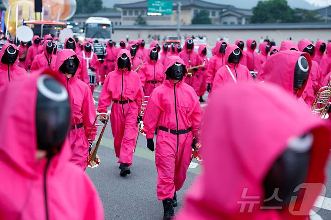 지난 28일 서울 광화문광장에서 열린 '오징어 게임 3' 홍보 행사에서 캐릭터로 분장한 사람들이 행진을 하고 있다ⓒ 로이터=뉴스1