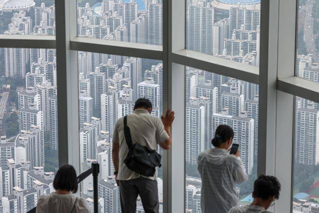 이재명 대통령이 "이번 대출 규제는 맛보기에 불과하다"고 추가 부동산 대책 도입을 시사한 3일, 관광객들이 서울 송파구 롯데월드타워 전망대에서 시내 아파트 단지를 바라보고 있다. 뉴스1