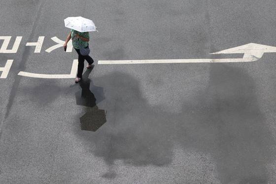 1일 경기도 파주시 임진각에서 관광객이 양산을 든 채 장맛비로 젖은 땅을 걷고 있다. 연합뉴스