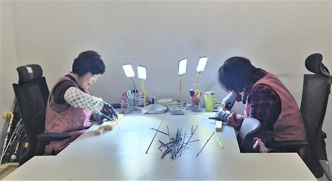 광명시 공공일자리 사업 중 하나인 '지역공동체일자리' 참여자들이 광명시 업사이클아트센터 내 우산수리센터에서 고장난 우산을 무료로 수리하고 있다. /사진제공=광명시